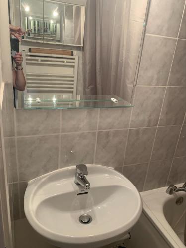 une salle de bain avec un lavabo et un miroir dans l'établissement Les Cimes, à Samoëns