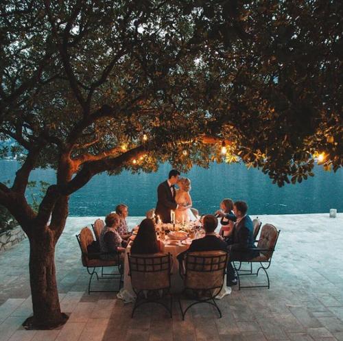 a group of people sitting at a table under a tree at Hotel Galathea in Kotor