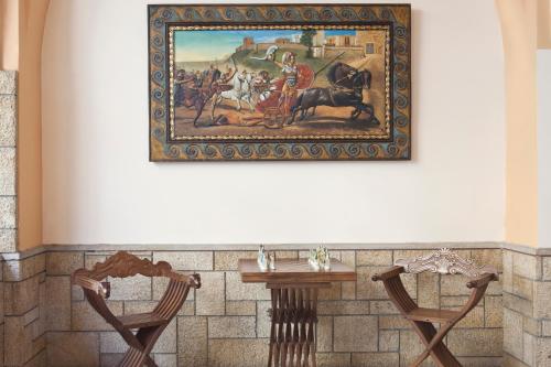 a painting hanging on a wall next to two chairs at Elizabeth Hotel in Athens