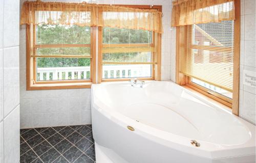 a white bath tub in a bathroom with a window at Amazing Home In Auklandshamn With House A Mountain View in Vestvik