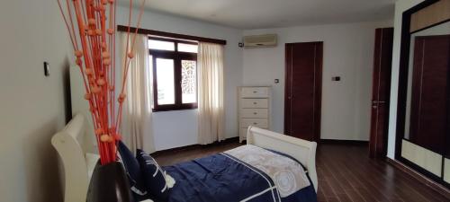 a bedroom with a bed and a window at English Point Residence Beach Apartments Mombasa in Mombasa