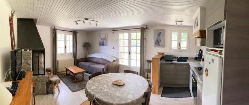 eine Küche und ein Wohnzimmer mit einem Tisch und einem Sofa in der Unterkunft la grange in Formiguères