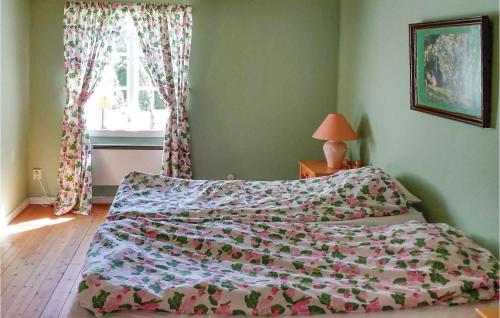 una camera da letto con un letto con un piumone e una finestra di Lovely Home In Motala With Wifi a Motala
