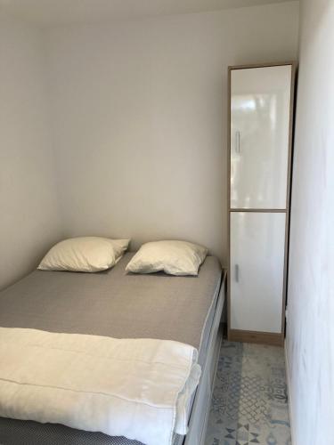 ein kleines Schlafzimmer mit einem Bett und einem Spiegel in der Unterkunft Appartement vue sur mer in Argelès-sur-Mer