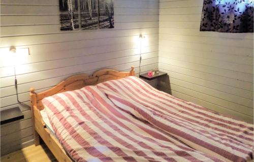 a bed with a striped comforter in a room at Raaen Hytteutleige 4 in Utne