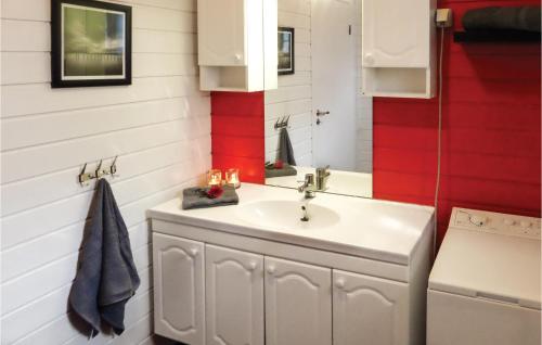 baño con lavabo y pared roja en Raaen Hytteutleige 4, en Utne