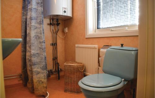 a bathroom with a blue toilet and a window at Awesome Home In Lttorp With Wifi in Löttorp