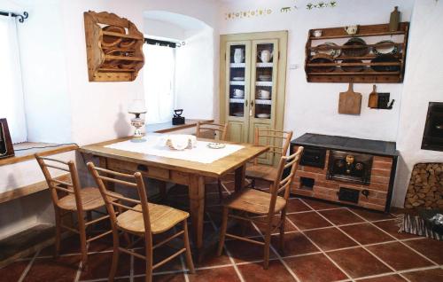 a kitchen with a wooden table and chairs and a fireplace at Beautiful Apartment In Mozirje in Mozirje