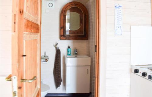 a bathroom with a small refrigerator and a sink at Cozy Home In Hagby With Kitchen in Hagby