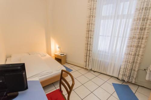 mały pokój z łóżkiem i oknem w obiekcie Stadthof Budget Hotel Basel City Center w Bazylei