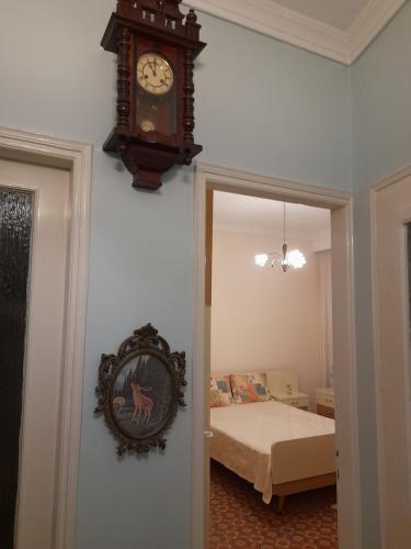 a clock hanging on a wall next to a bedroom at Friendly Philoxenia in Xanthi