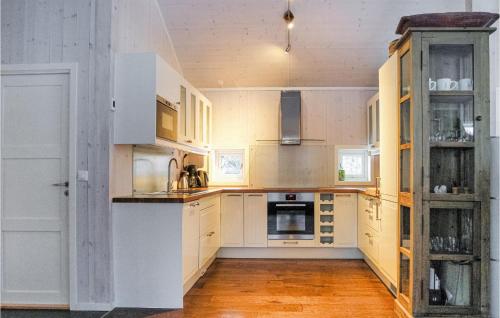 a kitchen with white cabinets and an open door at Sjusjøen-Pihl 89 in Sjusjøen