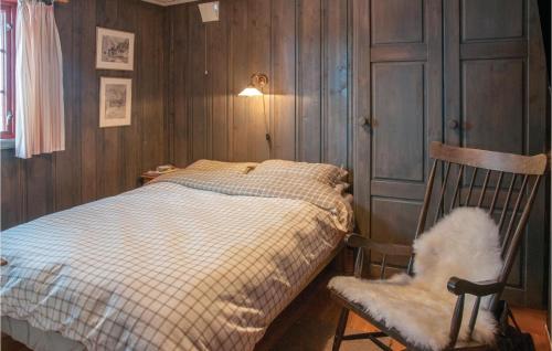 a bedroom with a bed and a rocking chair at Awesome Home In Rendalen With Kitchen in Rendalen