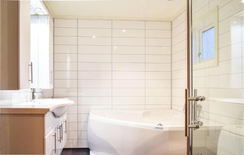 een witte badkamer met een bad en een wastafel bij Sjidyll in Vaka