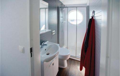 Baño blanco con lavabo y aseo en Aquacabin, en Leimuiden