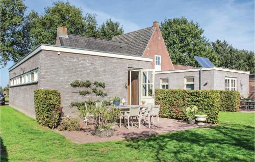 a brick house with a table and chairs in the yard at Amazing Home In Dongen With Kitchen in Dongen
