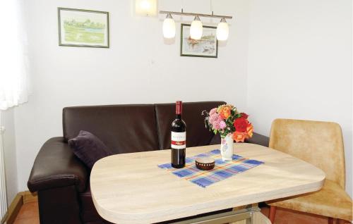 a bottle of wine and a vase of flowers on a table at Awesome Home In Insel Poel in Insel Poel
