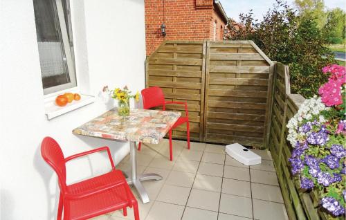 a patio with a table and chairs and flowers at Awesome Home In Insel Poel in Insel Poel