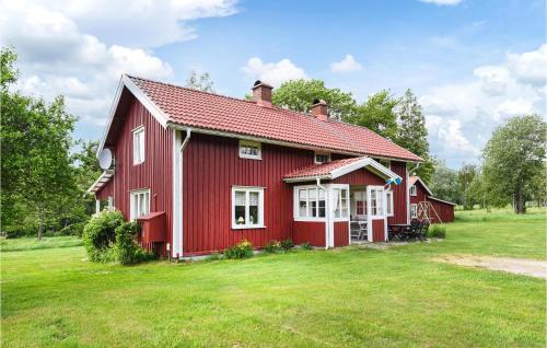 a red house with a red roof on a green field at Awesome Home In Ölsremma With Sauna in Ölsremma