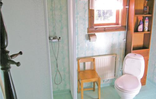 a bathroom with a pink toilet and a chair at Lovely Home In Trans With Kitchen in Sundhultsbrunn