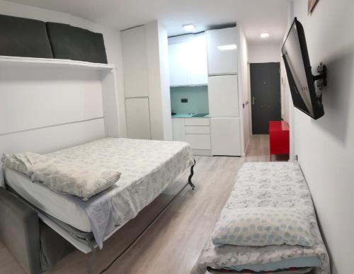 - une chambre avec un lit et une télévision murale dans l'établissement Torre Saltillo, à Torremolinos