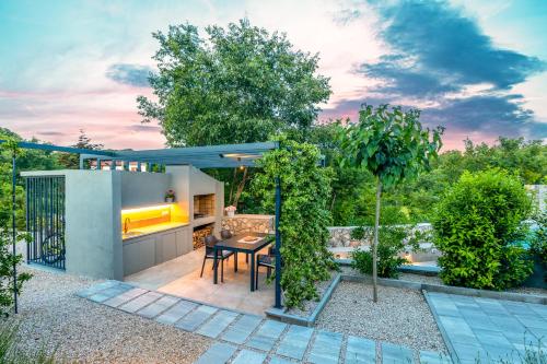 a patio with a table and chairs in a backyard at Luxury Jerini Barn in Krk