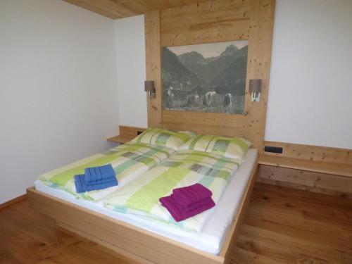 a bed with colorful blankets and pillows in a room at Alpenchalet Breitspitz in Partenen
