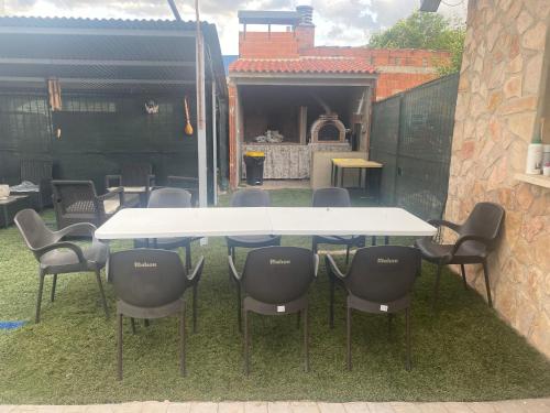 een tafel en stoelen in een tuin met een garage bij Apartamentos Rurales Hermanos Alcalá in Ibdes