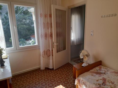 a bedroom with a bed and a window and a fan at Friendly Philoxenia in Xanthi