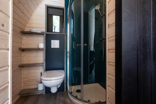 een kleine badkamer met een toilet en een douche bij Boomhuis met optioneel wellness - Vakantiepark de Schreiershoek in Dokkum