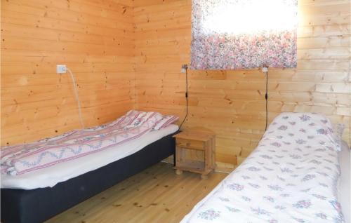 a room with two beds in a wooden cabin at Raaen Hytteutleige 1 in Utne
