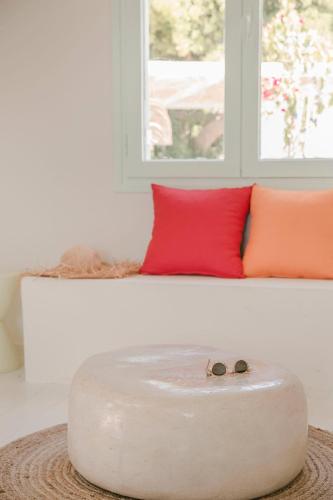 a coffee table in front of a bed with red pillows at Bohemian Nest - Cheerful 2-Bedroom Villa with pool in Dhavgáta