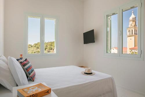 a white room with a table and two windows at Bohemian Nest - Cheerful 2-Bedroom Villa with pool in Dhavgáta
