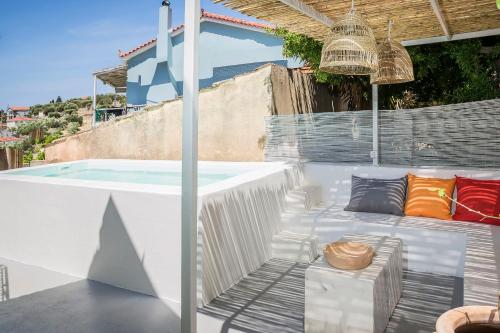 a patio with a bench next to a swimming pool at Bohemian Nest - Cheerful 2-Bedroom Villa with pool in Dhavgáta