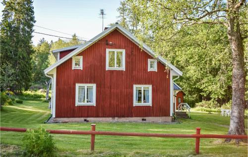 a red barn with a tree in front of it at Awesome Apartment In Rönneshytta in Rönneshytta