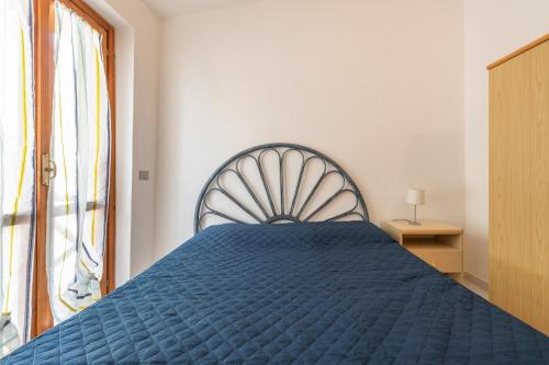 a blue bed in a room with a window at Villetta Teresa in Costa Rei