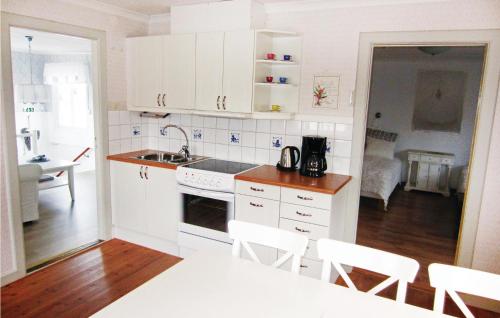 a kitchen with white cabinets and a table and chairs at Stunning Apartment In Kungshamn in Kungshamn