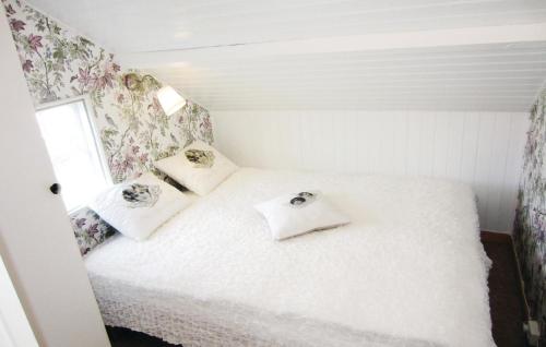 a small bedroom with a white bed with flowers on the wall at 3 Bedroom Beautiful Apartment In Kungshamn in Kungshamn