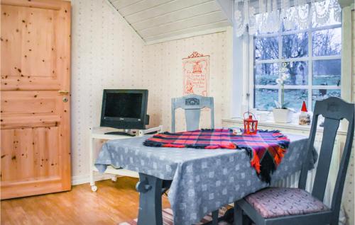 Zimmer mit einem Tisch mit 2 Stühlen und einem Computer in der Unterkunft Lovely Home In Asarum With Kitchen in Asarum