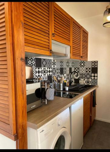 une cuisine avec un lave-linge et un lave-linge dans l'établissement Logement charmant au coeur de la station, à Besse-et-Saint-Anastaise