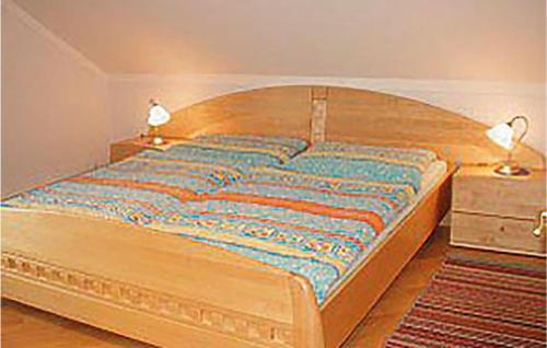 a bedroom with a large wooden bed with two lamps at 2 Bedroom Nice Apartment In Schnbach in Bärnkopf