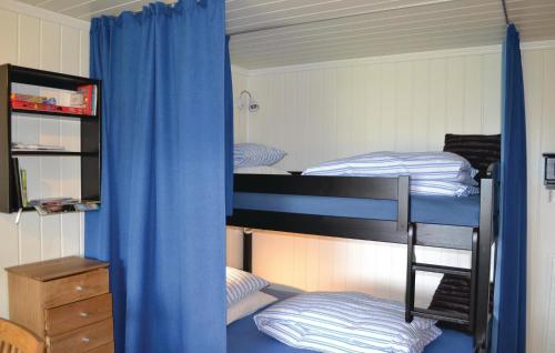a bedroom with two bunk beds with blue curtains at Beautiful Apartment In Norheimsund With House Sea View in Norheimsund