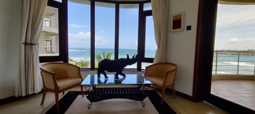 a room with a statue of a donkey on a table in front of windows at English Point Residence Beach Apartments Mombasa in Mombasa