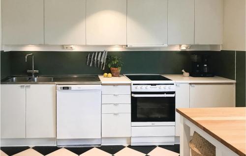 a kitchen with white cabinets and a stove top oven at Nice Home In Gislaved With Sauna in Gislaved