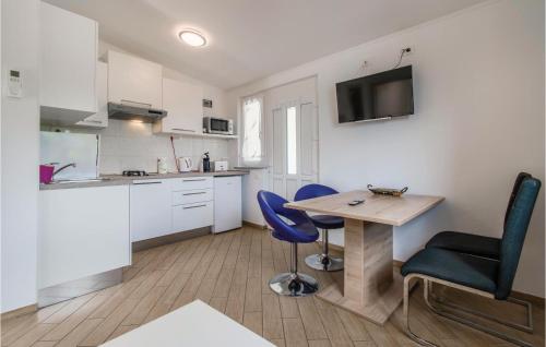a kitchen with a table and two blue chairs at Cozy Apartment In Piran With Wifi in Piran