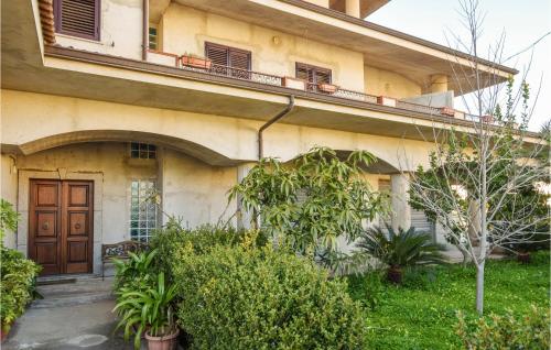 a building with a wooden door and some plants at Gorgeous Apartment In Ricadi With Wifi in Ricadi