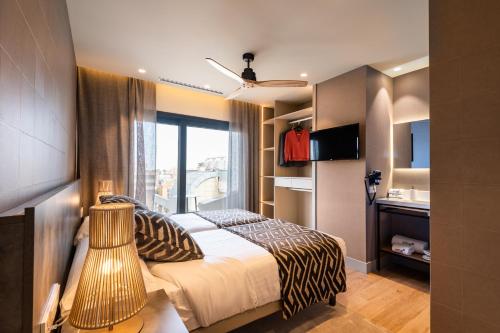 瓦伦西亚Apartamentos Core Suites Valencia的一间卧室配有一张带窗户和水槽的床