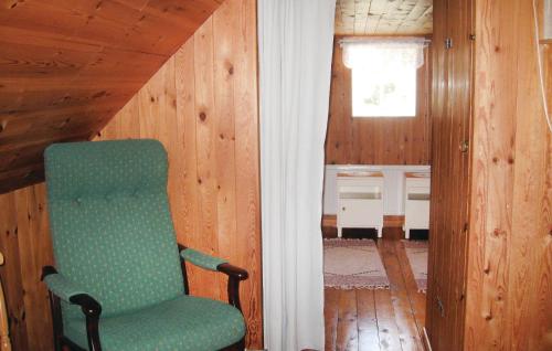 a green chair sitting in a room with wooden walls at Holiday Home Katthammarsvik 21 in Katthammarsvik