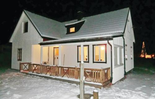 a small white house in the snow at night at Holiday Home Björkvägen Höör in Höör