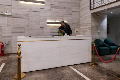 Un homme debout à un comptoir dans une pièce dans l'établissement فندق ميروت-Mirot Hotel, à Khobar